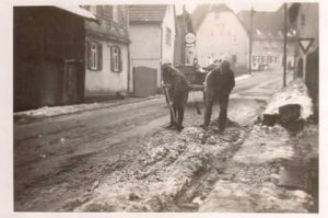 Deutsche Soldaten schaufeln Schnee, im Hintergrund links der Laden Mänscher/Knorr, 1940, Foto von R. Wick